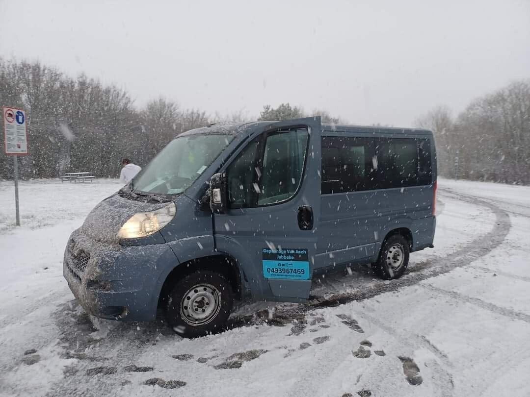 Bijstandswagen van Depannage Van Asch met het telefoonnummer op de flank, tijdens een sneeuwbui